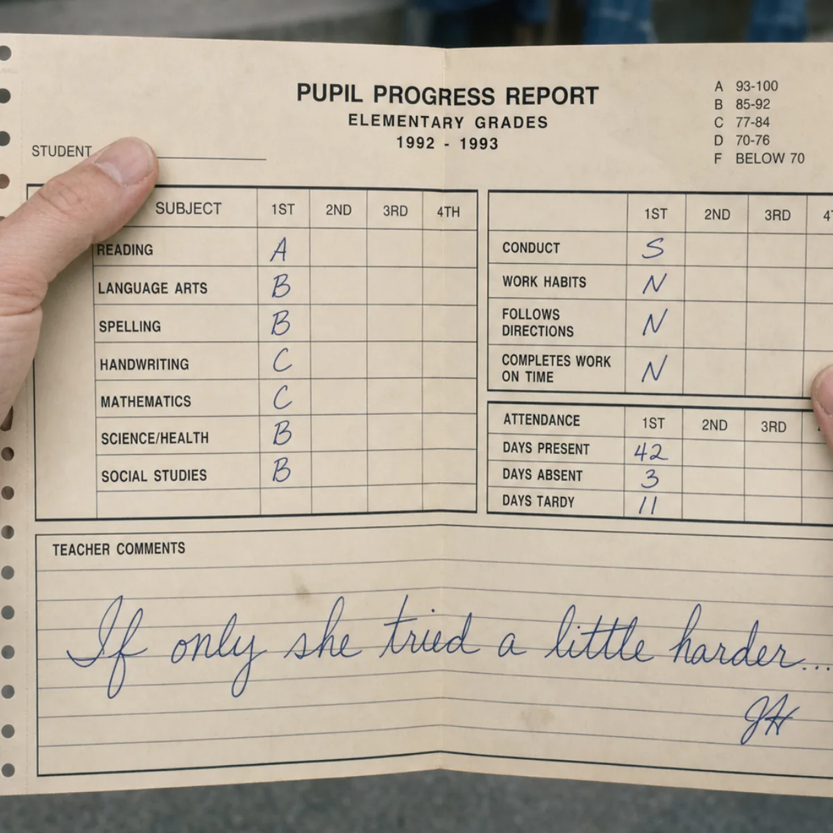 A 1992-1993 school report card open in someone's hands, with the teacher's handwritten comment.